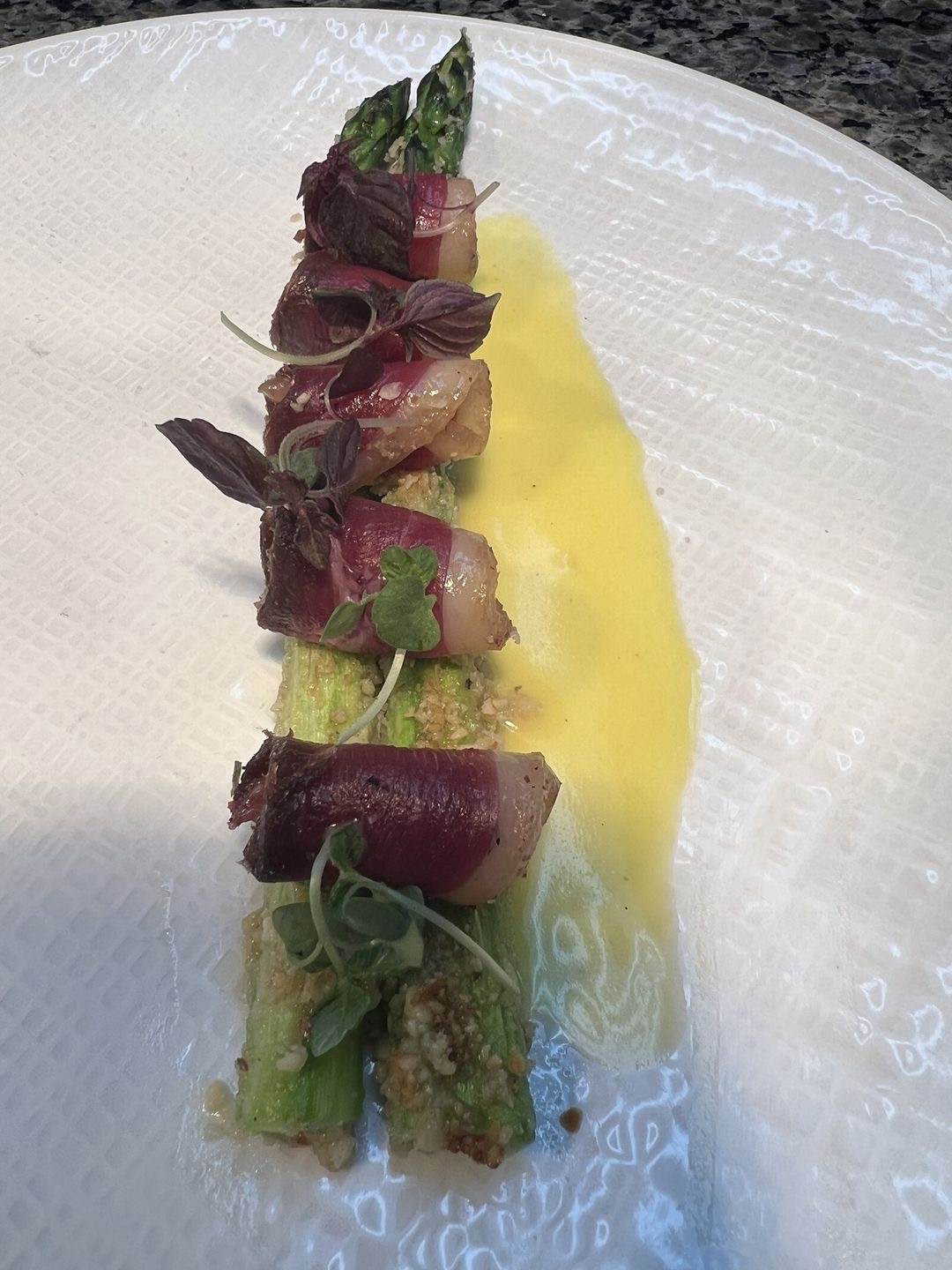 Duck prosciutto slices over asparagus with orange citronette