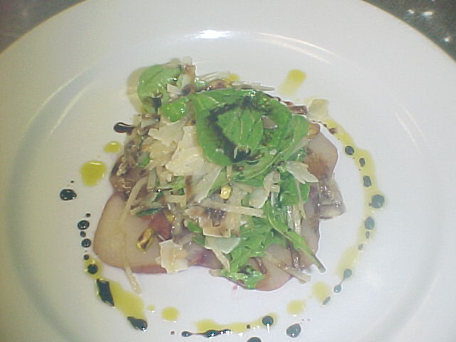 Pear salad with arugula, Pecorino Toscano and pistachios on balsamic-poached pear